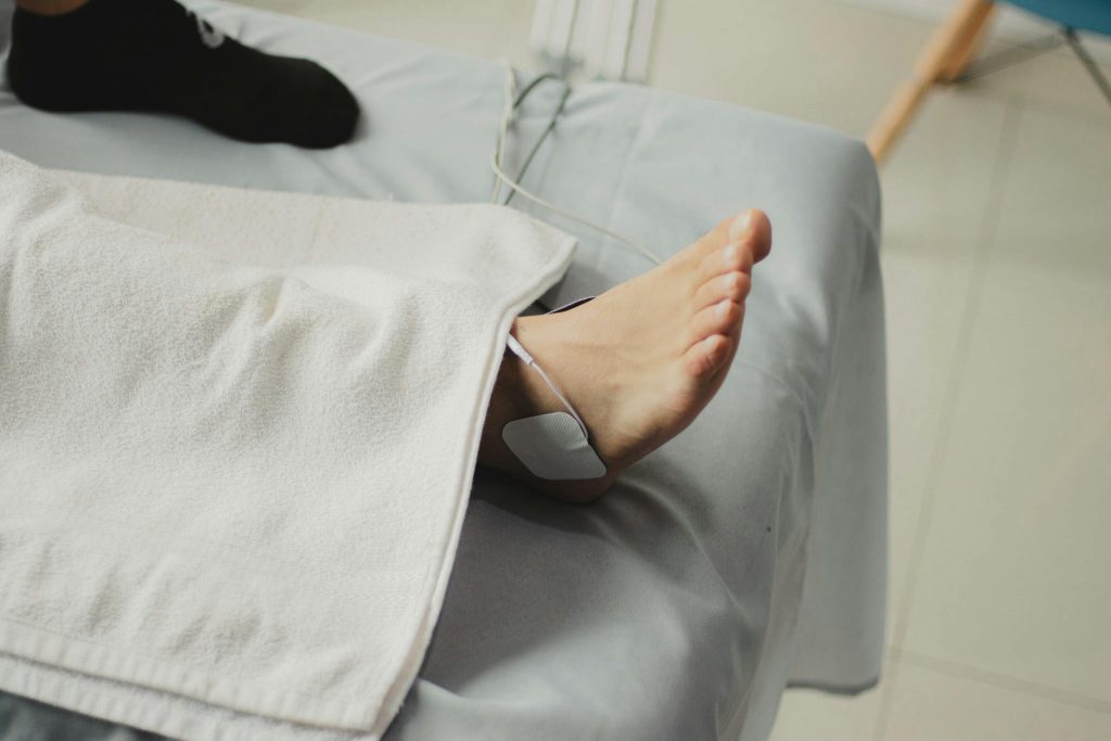 A close-up image of a bare foot with a medical electrode, suggesting a healthcare setting.